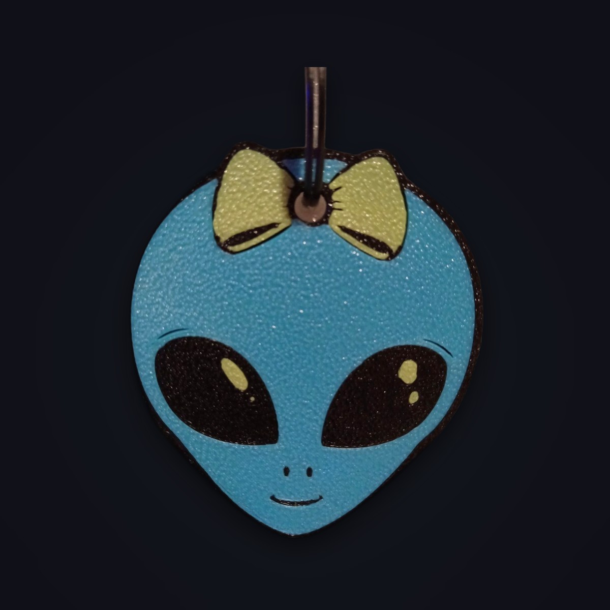 Lilien keychain: blue alien head wearing a green bow